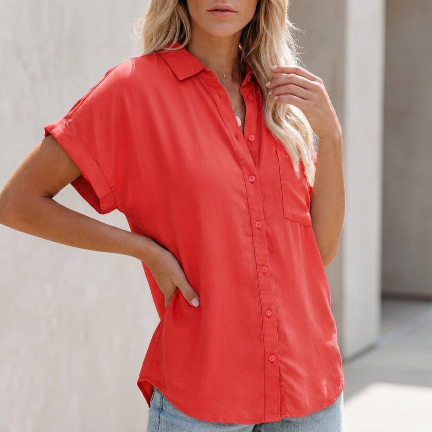 Red women's collared button-up blouse by FJØRNA with cuffed sleeves and chest pocket, displayed on a neutral background.
