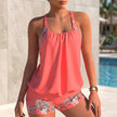 Red FJØRNA women's summer swimsuit with halter neck and flowy design, perfect for stylish beachwear and swimming.