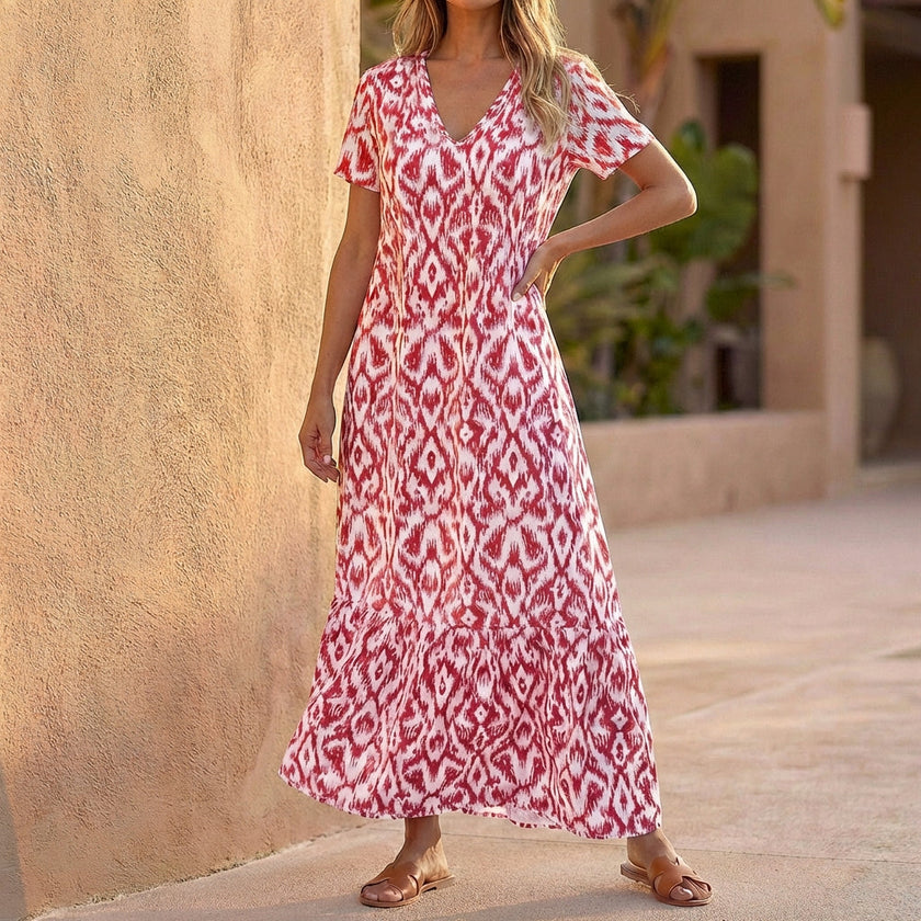 Red FJØRNA V-neck maxi dress with ruffled hem, flowing fabric, and elegant design for a stylish, comfortable look.