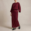 Red two-piece woven skirt suit by FJØRNA featuring textured fabric, draped high-waist silhouette, perfect for elegant occasions.