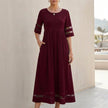 Red FJØRNA A-line maxi dress with mesh panels and pockets, flowing design perfect for casual or formal wear.