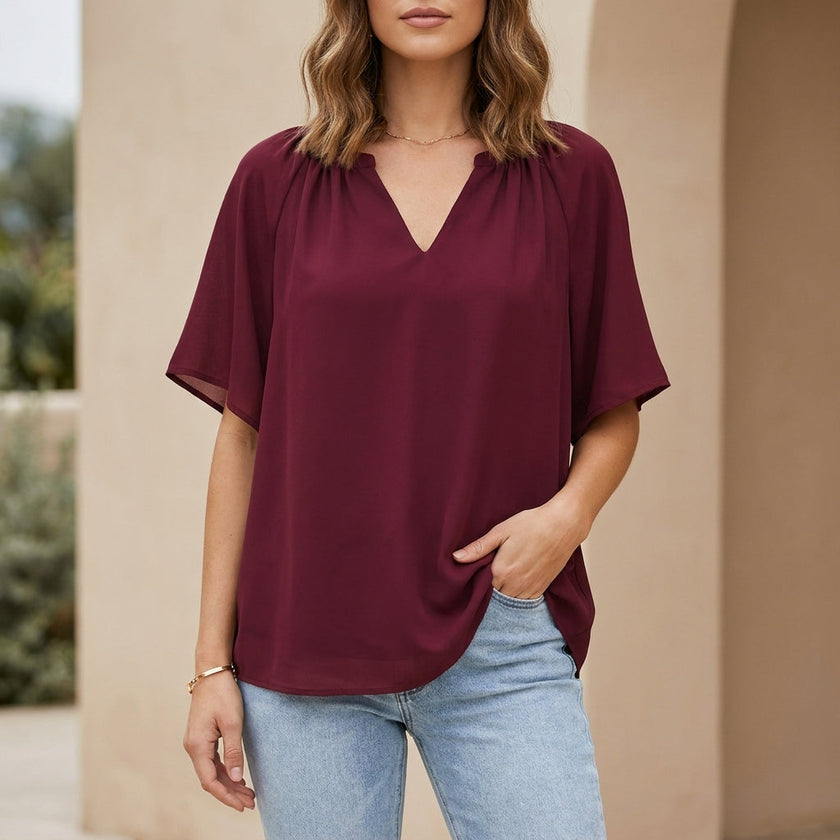Red women's summer blouse with v-neck and flutter sleeves by FJØRNA, showcasing a stylish and lightweight top for warm weather.