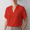 Red FJØRNA women's summer blouse with a V-neck, short flowy sleeves, perfect for warm weather and casual styling.