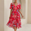 FJØRNA Sofia Amoretti flowing red chiffon wrap midi dress with tie waist, showcasing elegant drape and long sleeves.