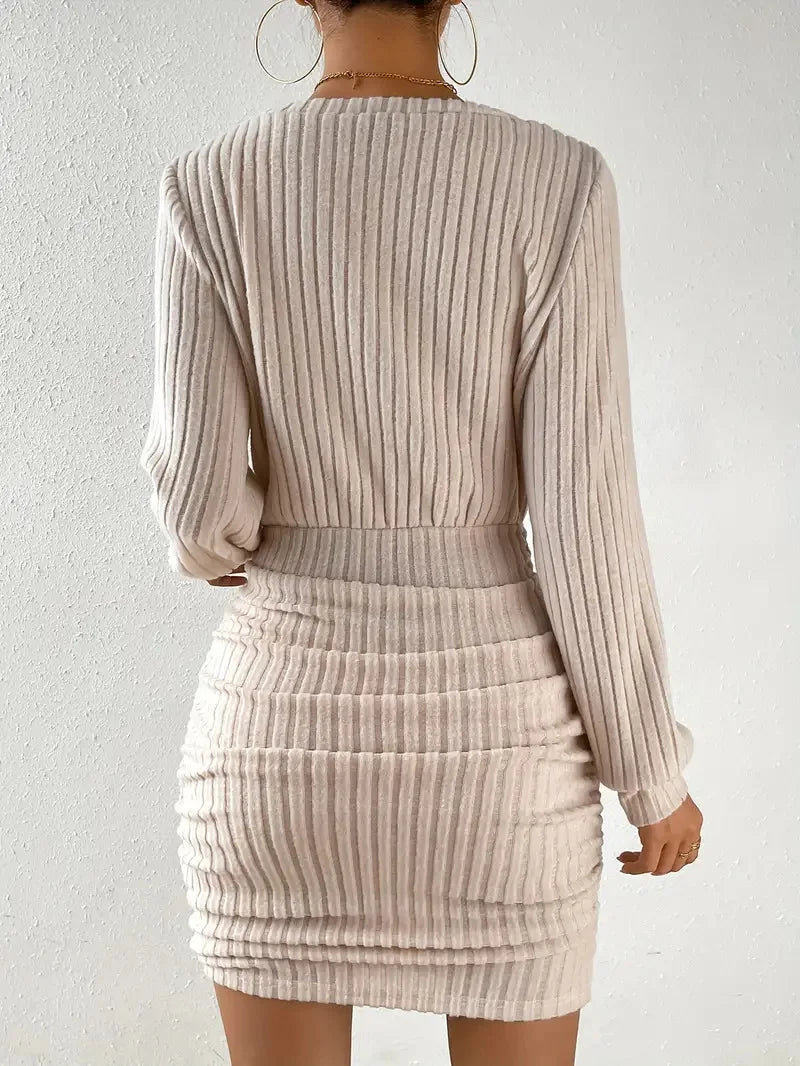 FJØRNA ribbed knit mini dress displayed on a hanger, featuring a fitted silhouette and textured ribbed fabric.