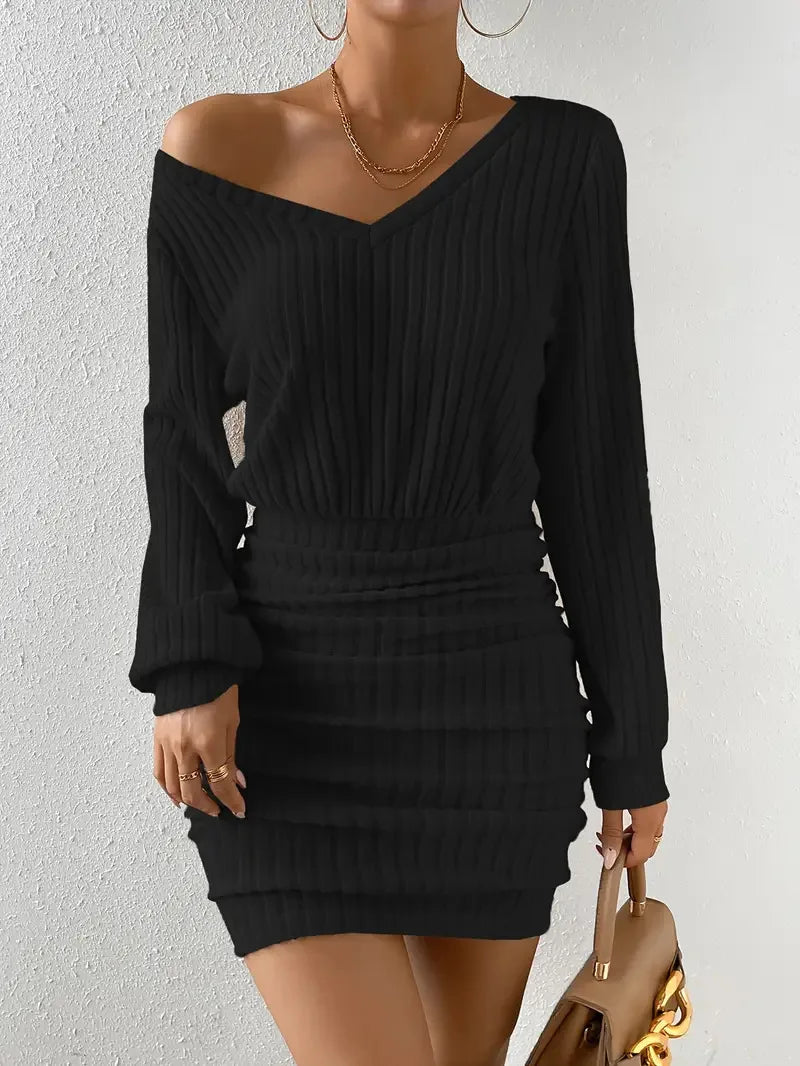 FJØRNA ribbed knit mini dress displayed on a model, featuring a fitted silhouette with long sleeves and a high neckline.