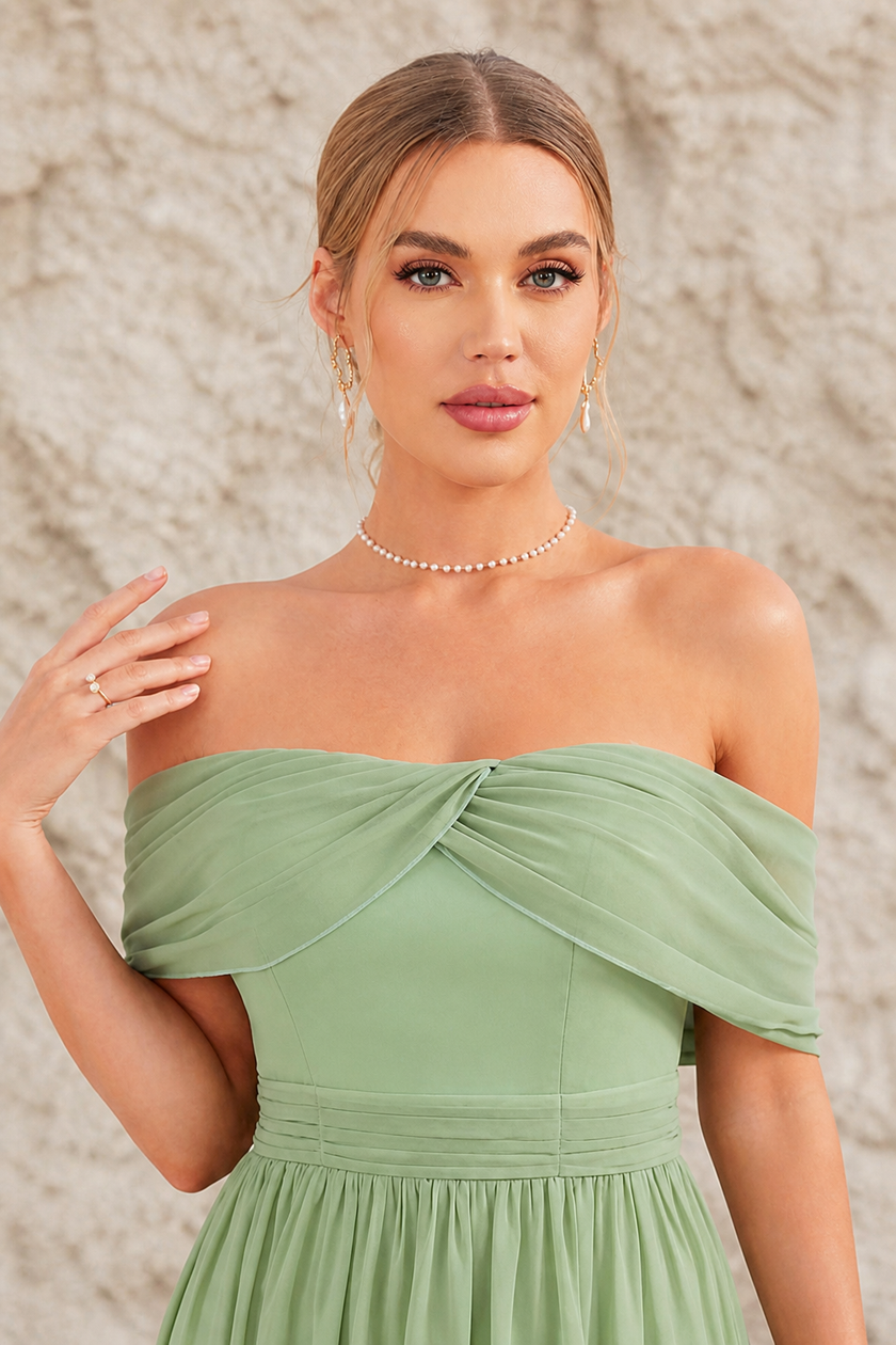 FJØRNA sage green backless dress displayed on a hanger, showcasing its elegant sleeveless design and flowing fabric.