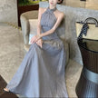 FJØRNA ruched halter midi dress displayed on a mannequin, featuring a fitted bodice and flowing skirt for elegant style.
