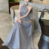 FJØRNA ruched halter midi dress displayed on a mannequin, featuring a fitted bodice and flowing skirt for elegant style.
