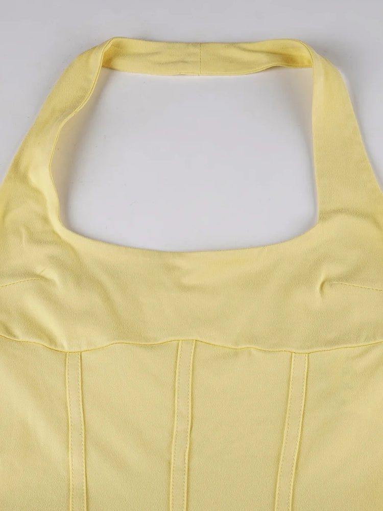 FJØRNA ruffled halter mini dress with soft fabric and stylish design, shown on a model featuring a sleeveless, flared silhouette.