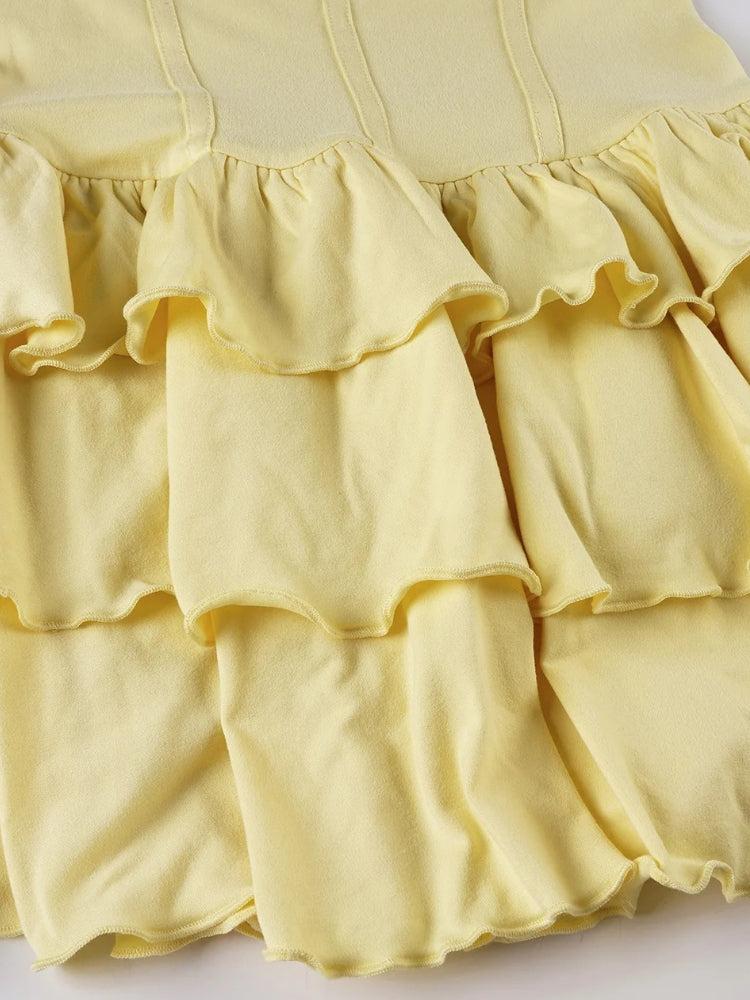 FJØRNA ruffled halter mini dress with sleeveless design, featuring a fitted bodice and playful ruffle details for a stylish look.