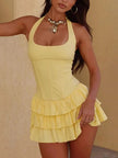 FJØRNA ruffled halter mini dress with a fitted bodice and flared skirt, featuring delicate ruffle details and halter neckline.