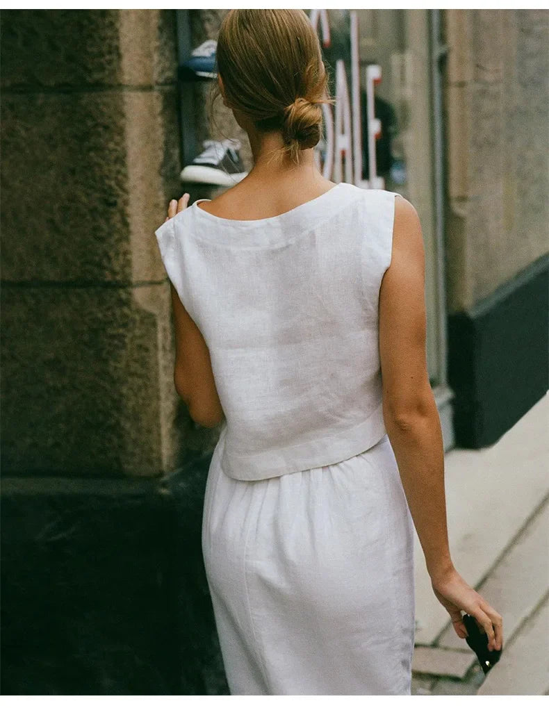 FJØRNA women's linen crop top with short sleeves, lightweight and breathable, shown in a natural beige color.