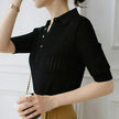 FJØRNA women's ribbed knit polo blouse, close-up of the fitted, ribbed fabric and classic collar on a stylish top.