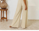 FJØRNA women's linen wide-leg trousers with elastic waist and ruffle details, shown on a model, perfect for casual or summer wear.