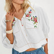 Embroidered women's crop top from FJØRNA featuring colorful floral embroidery and a fitted sleeveless design.