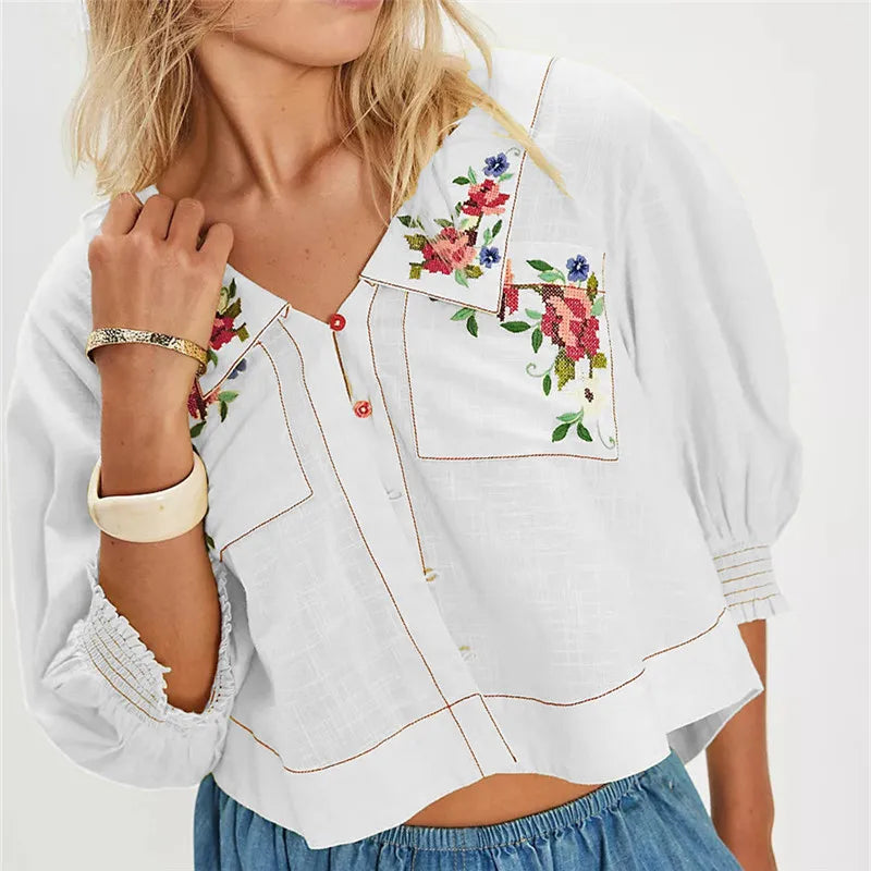 Embroidered women's crop top from FJØRNA featuring colorful floral embroidery and a fitted sleeveless design.