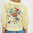Embroidered women's crop top by FJØRNA featuring intricate floral embroidery and a stylish, fitted design.