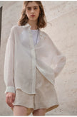 FJØRNA women's linen shirt, lightweight and breathable top, shown in a relaxed fit with long sleeves and natural linen fabric.