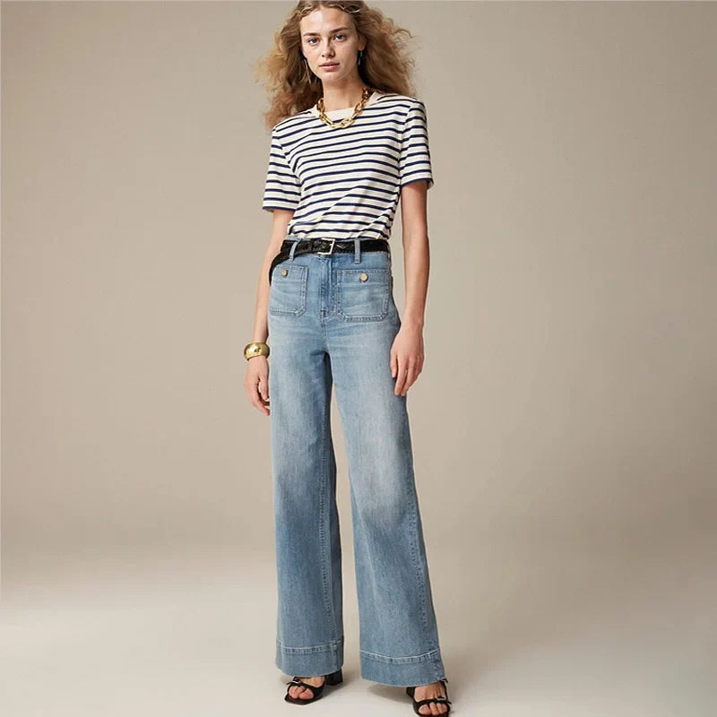 Women’s wide-leg cotton jeans by FJØRNA featuring high waist and relaxed fit, shown on a model in a casual outdoor setting.