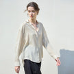 Women’s linen shirt by FJØRNA, casual and breathable top with long sleeves and a relaxed fit, shown in a neutral color.