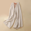 Women’s linen wide-leg trousers by FJØRNA with drawstring waist, relaxed fit, and lightweight breathable fabric.