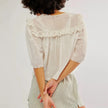 FJØRNA women's cotton blouse with ruffle details, featuring a stylish, feminine top in soft fabric and elegant design.