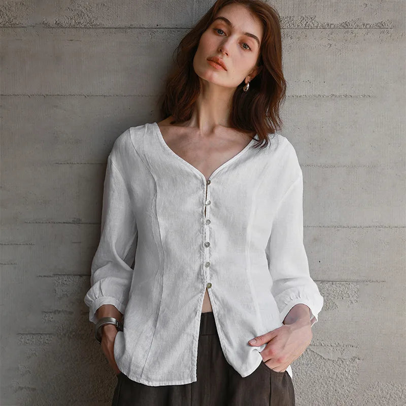 FJØRNA tailored V-neck linen top in light, breathable fabric, featuring a relaxed fit and subtle stitching details.