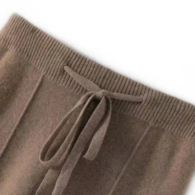 FJØRNA women's merino wool wide-leg high-waist trousers with a tailored fit, shown in natural color on a model.