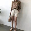 FJØRNA women's linen shirt with open collar, lightweight and breathable top, shown in a relaxed fit on a model.
