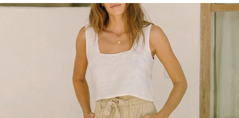FJØRNA women's linen top with ruffle detail, featuring a lightweight, breathable fabric and feminine design.