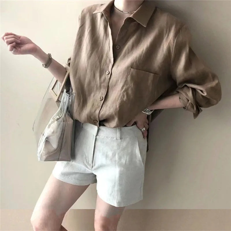 Women’s linen shirt with open collar by FJØRNA, displayed on a hanger, featuring a relaxed fit and lightweight breathable fabric.