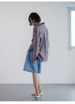 FJØRNA women's linen pleated shirt with long sleeves and a relaxed fit, shown on a hanger against a neutral background.