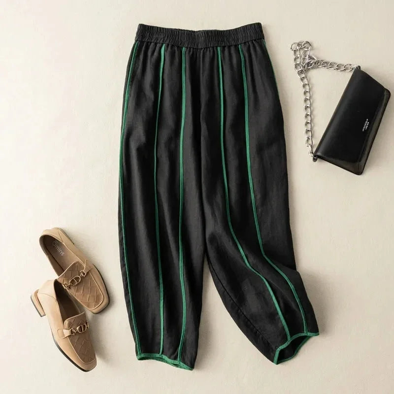 FJØRNA women's linen wide-leg trousers with elastic waist, showing relaxed fit and lightweight fabric in a natural pose.