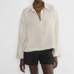 FJØRNA women's linen polo top with collar, lightweight and breathable, shown in a natural beige color on a model.