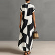 FJØRNA Victoria printed white button-down maxi dress with floral pattern, flowing fabric, and long sleeves.