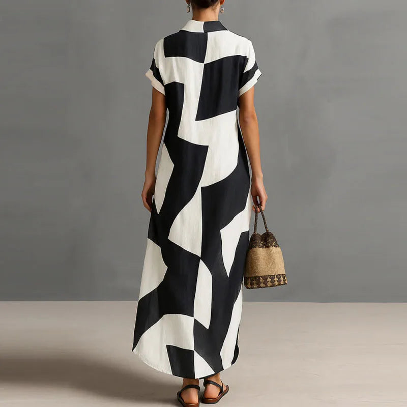 FJØRNA Victoria printed white button-down maxi dress with floral pattern, flowing fabric, and long sleeves.