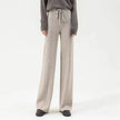 Women’s wide-leg merino wool trousers by FJØRNA featuring high waist and relaxed fit, shown in natural beige fabric.