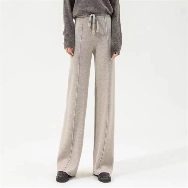 Women’s wide-leg merino wool trousers by FJØRNA featuring high waist and relaxed fit, shown in natural beige fabric.