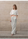 FJØRNA linen crop top for women with short sleeves, lightweight and breathable, shown in a natural fabric texture and relaxed fit.