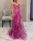 Elegant floral V-neck maxi dress for women by FJØRNA, featuring a flowing silhouette and vibrant floral pattern.
