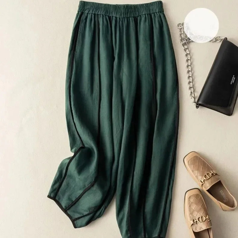 Women's linen wide-leg trousers with elastic waist from FJØRNA, shown in a relaxed fit with natural fabric texture.