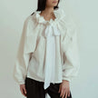 FJØRNA women's cotton blouse with ruffle detail, featuring a feminine and stylish design perfect for casual or dressy occasions.