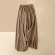 FJØRNA linen wide-leg women's trousers with drawstring waist, relaxed fit and casual style, shown on a model.
