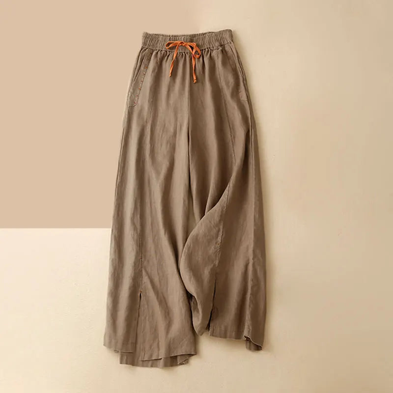 FJØRNA linen wide-leg women's trousers with drawstring waist, relaxed fit and casual style, shown on a model.