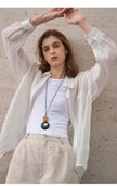 FJØRNA women's linen shirt, stylish and breathable top in soft linen fabric, displayed on a hanger.