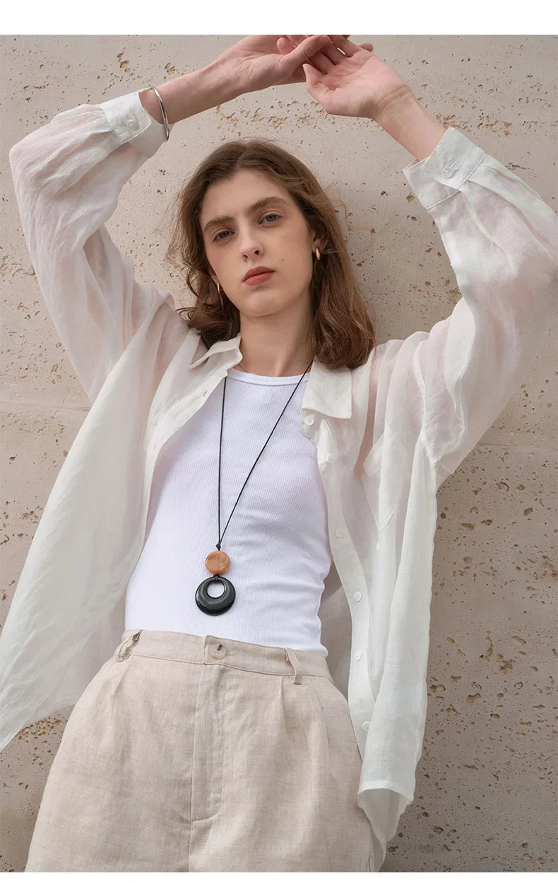 FJØRNA women's linen shirt, stylish and breathable top in soft linen fabric, displayed on a hanger.
