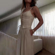 FJØRNA women's sleeveless linen dress with a relaxed fit, natural beige color, and lightweight fabric perfect for warm weather.