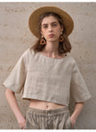 FJØRNA linen crop top for women with short sleeves, lightweight and breathable, shown in natural fabric texture.
