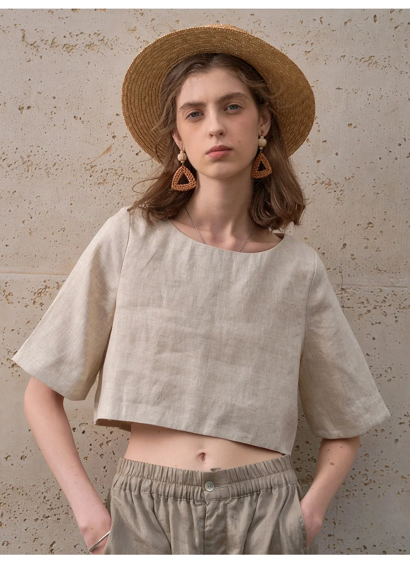 FJØRNA linen crop top for women with short sleeves, lightweight and breathable, shown in natural fabric texture.
